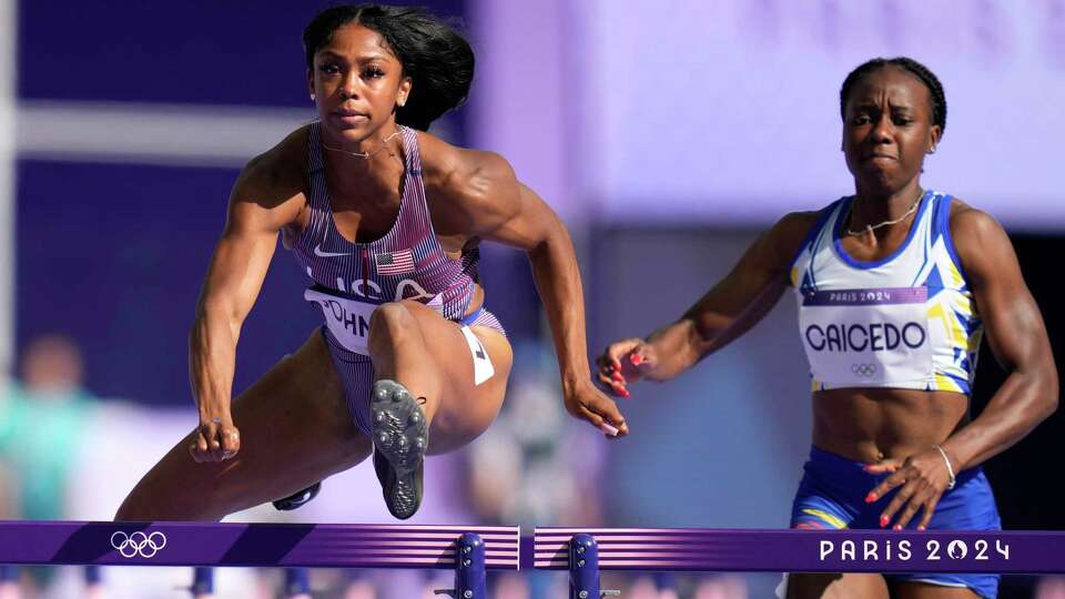 Alaysha Johnson, left, of the United States and Maribel Vanessa Caicedo, of Ecuador, compete in the women's 100-meter hurdles heats at the 2024 Summer Olympics, Wednesday, Aug. 7, 2024, in Saint-Denis, France. (AP Photo/Ashley Landis)