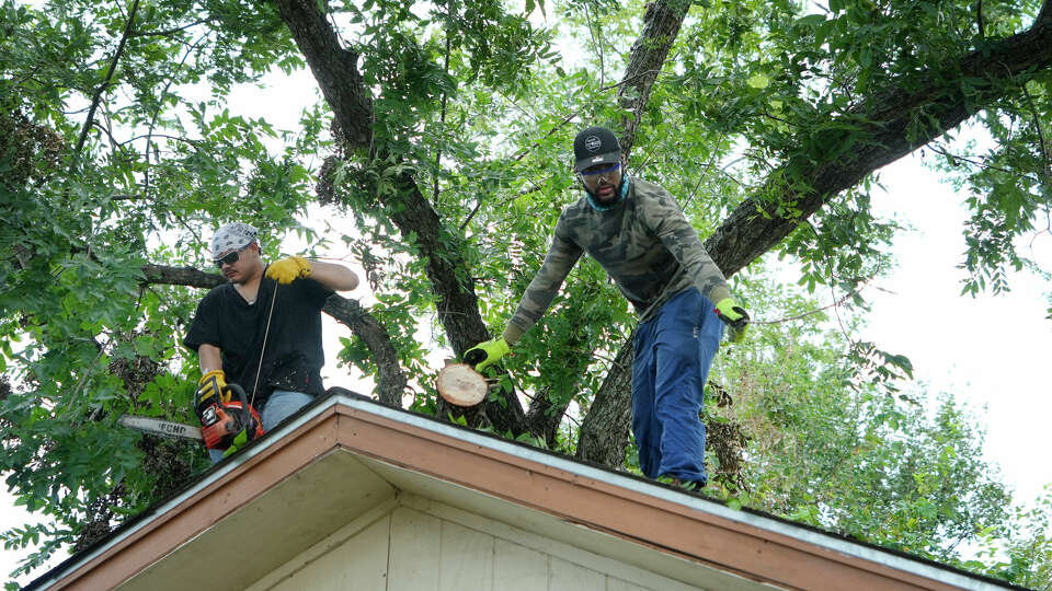 Damion Cantu, left, with Iron Workers Union Local 135 and Jerry Bynum, right, with Pipe Fitters Local Union 211 work to remove a fallen pecan tree as they and other union member volunteers work to clear Hurricane Beryl debris from the East Aldine home of Lynn Williams Tuesday, July 16, 2024, in Houston.