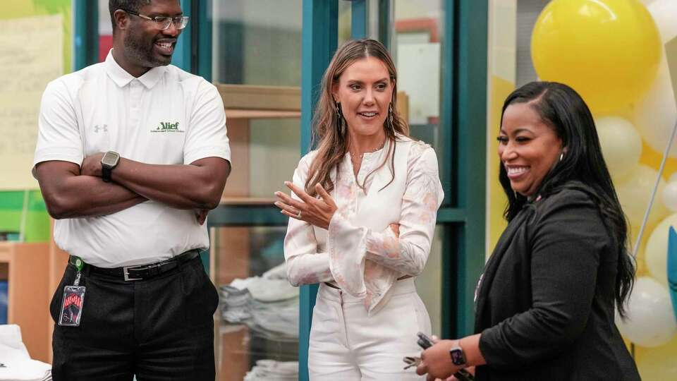 Kendra Scott, center, talks with Alief Superintendent Anthony Mays, left, and Best Elementary principal Brandan Clark, right, during Kendra Scott Foundation's Yellow Library program distributing 5,000 books to 600 students at Best Elementary School in Alief ISD on Thursday, Aug. 8, 2024, in Houston.