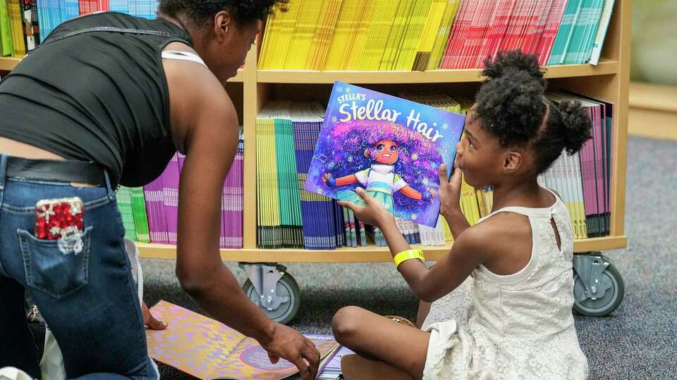 Naveah Bonner, 5, picks out a free book with her mother Christy Pugh during Kendra Scott Foundation's Yellow Library program distributing 5,000 books to 600 students at Best Elementary School in Alief ISD on Thursday, Aug. 8, 2024, in Houston.