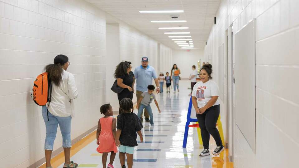 Families explore the halls off Silos Elementary School looking for their classroom on Thursday, Aug. 8, 2024, in San Antonio, Texas. Silos Elementary is a new elementary school in Medina Valley ISD, a fast-growing district that encompasses parts of Medina County and San Antonio's far West Side, to accommodate growth and help relieve crowded campuses.