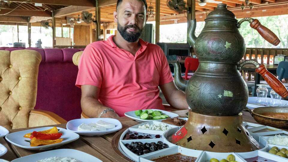 Owner Bahadir Bastas sits at a table filled with a traditional Turkish breakfast or kahvalti served mornings in the restaurant at Waterstone Ranch Turkish farm Friday, Aug 9, 2024 in Rosharon.