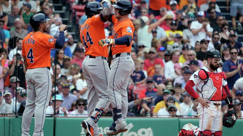 Houston Astros' Alex Bregman celebrates his three-run home run with Yordan Alvarez (44) that also drove in Pedro León (4) as Boston Red Sox catcher Connor Wong kneels at home plate during the fifth inning of a baseball game, Sunday, Aug. 11, 2024, in Boston. (AP Photo/Michael Dwyer)