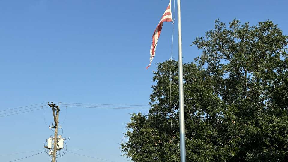 The tattered flag outside Mickey Leland College Preparatory Academy for Young Men, which was replaced by a donor before the start of the 2024-25 school year.