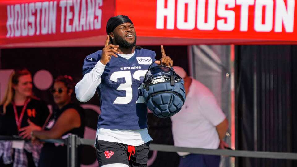 Houston Texans running back Dare Ogunbowale (33) points to the sky as he walks onto the practice field during an NFL training camp Sunday, Aug. 11, 2024, in Houston.