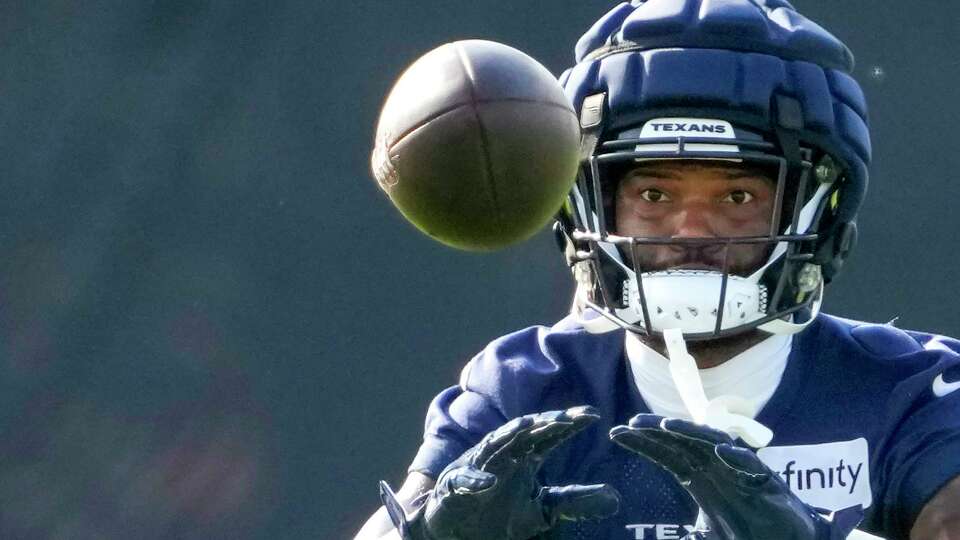 Houston Texans wide receiver Nico Collins (12) eyes a ball as he runs a drill during an NFL training camp Sunday, Aug. 11, 2024, in Houston.