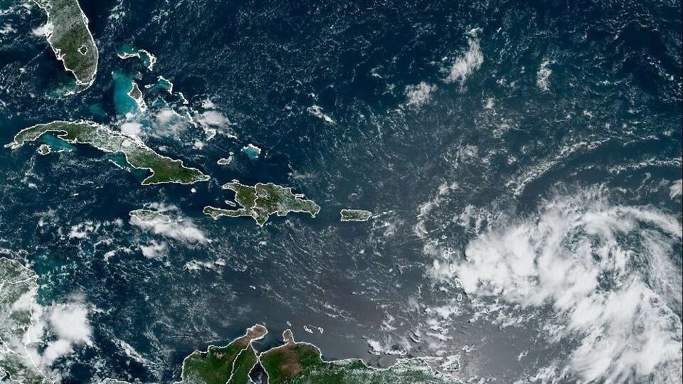 A potential tropical cyclone, lower right, seen in this weather satellite photo taken Monday as a cluster of clouds in the Atlantic, was expected to become a tropical storm named Ernesto this week.