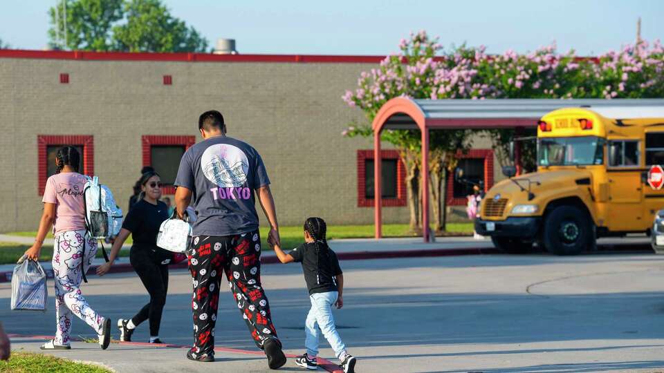 Parents walk their children to Aldine ISD’s Hinojosa EC/Pre-K/K School for the first day of school on Monday, Aug. 12, 2024 in Houston.