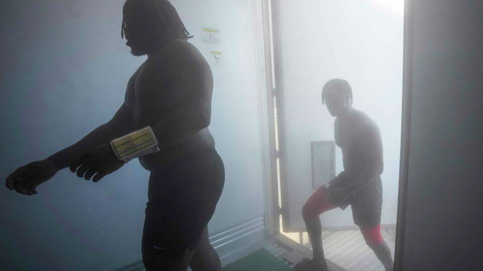 University of Houston football players walk into the Cougars’ “Club Ice” cooling unit after practice on Thursday, Aug. 15, 2024 in Houston. Cougars wanting to counter the effects of practicing in the Houston heat can step into a container unit that's kept between zero and minus-8 degerees. They players go into the cold for three minute stretches each time.