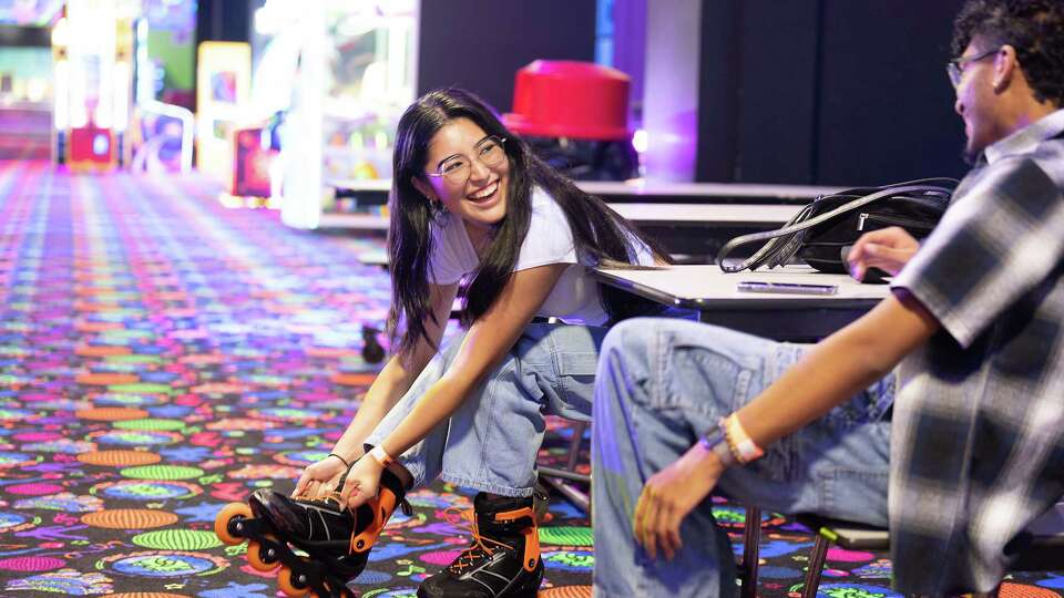 Erica Cortez laughs with Victor Montelongo as they tie their rental skates on at Skateworld on Thursday, Aug. 15, 2024 in Deer Park. The family-owned business had to close for 16 months after being struck by a tornado in 2023.