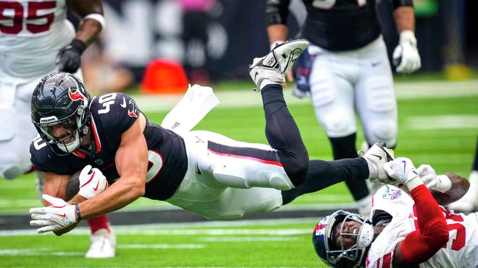 Houston Texans tight end Dalton Keene (40)] is tripped up by New York Giants linebacker K.J. Cloyd (57) during the second half of an NFL preseason football game Saturday, Aug. 17, 2024, in Houston.