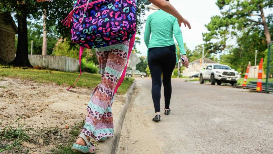 Kaley Greear walks with her daughter to Cy-Fair ISD's first day of school on Monday, Aug. 19, 2024 in Cypress.