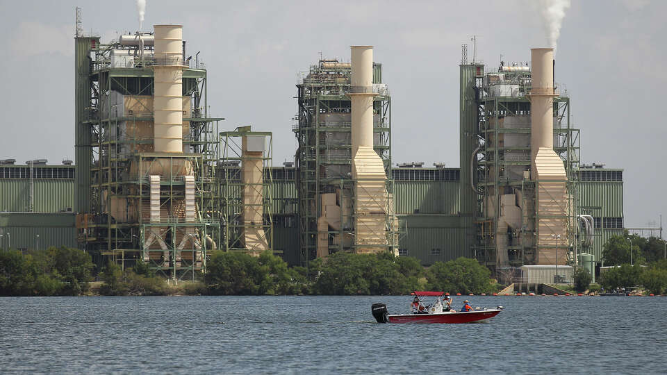 A boat cruises by a CPS Energy power plant on Braunig Lake on Saturday, August 9, 2014. The lake is replenished by the recycled water used at the CPS Energy power plant. The lake is frequented by fishermen and boaters. (Kin Man Hui/San Antonio Express-News)