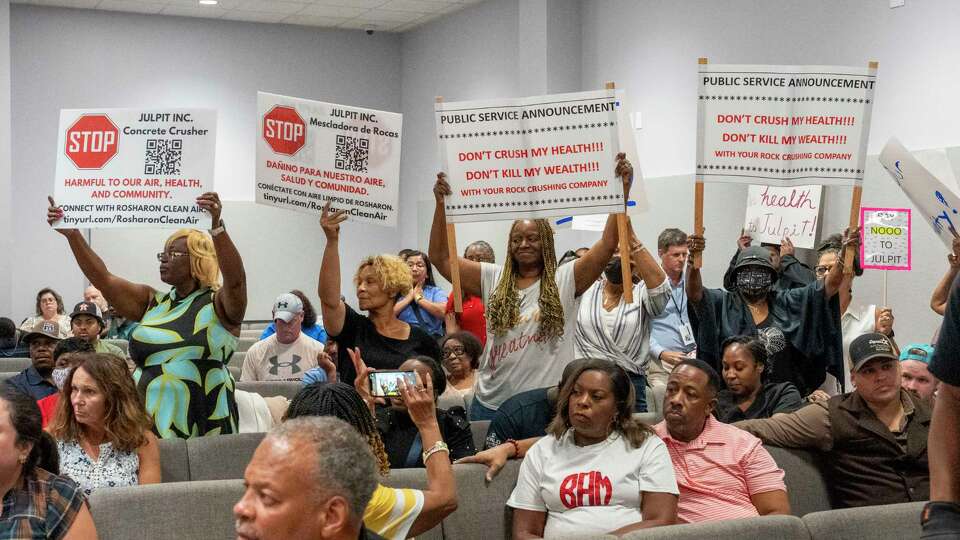 Citizens hold signs showing their opposition to a proposed Julpit Inc. concrete crushing facility Tuesday, Aug 20, 2024 during a forum at Restoration City Life Center in Rosharon.