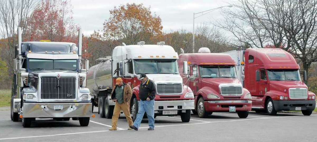 Truckers Butch Savage, lef, from Fultonham, N.Y., and David Bass, right, from Cape Coral, Fla., talk outside their trucks at the Schodack Interstate 90 rest stop in Schodack, N.Y. on Monday, Nov. 1, 2010. Savage's son-in-law was trucker, Jason Rivenburg, who was murdered in his truck while on a trip in South Carolina. Rivenburg was spending the night in the lot of an abandoned gas station when he was shot. (Paul Buckowski / Times Union)