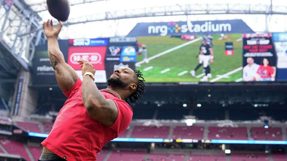 Houston Texans running back Joe Mixon tosses a football to fans before a NFL preseason football game at NRG Stadium, Saturday, Aug. 24, 2024, in Houston.