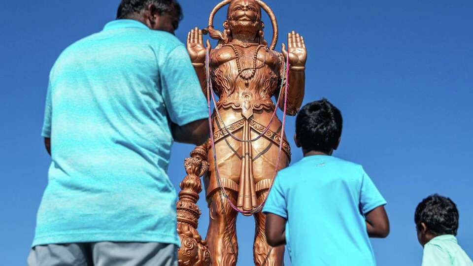 Elangovan, 45, and his sons Nitish, 9, and Thashan, 4, visit the newest statue at Shri Ashtalakshmi Temple, of the monkey god, Hanumanon, is photographed on Sunday, Aug. 25, 2024 in Sugar Land.