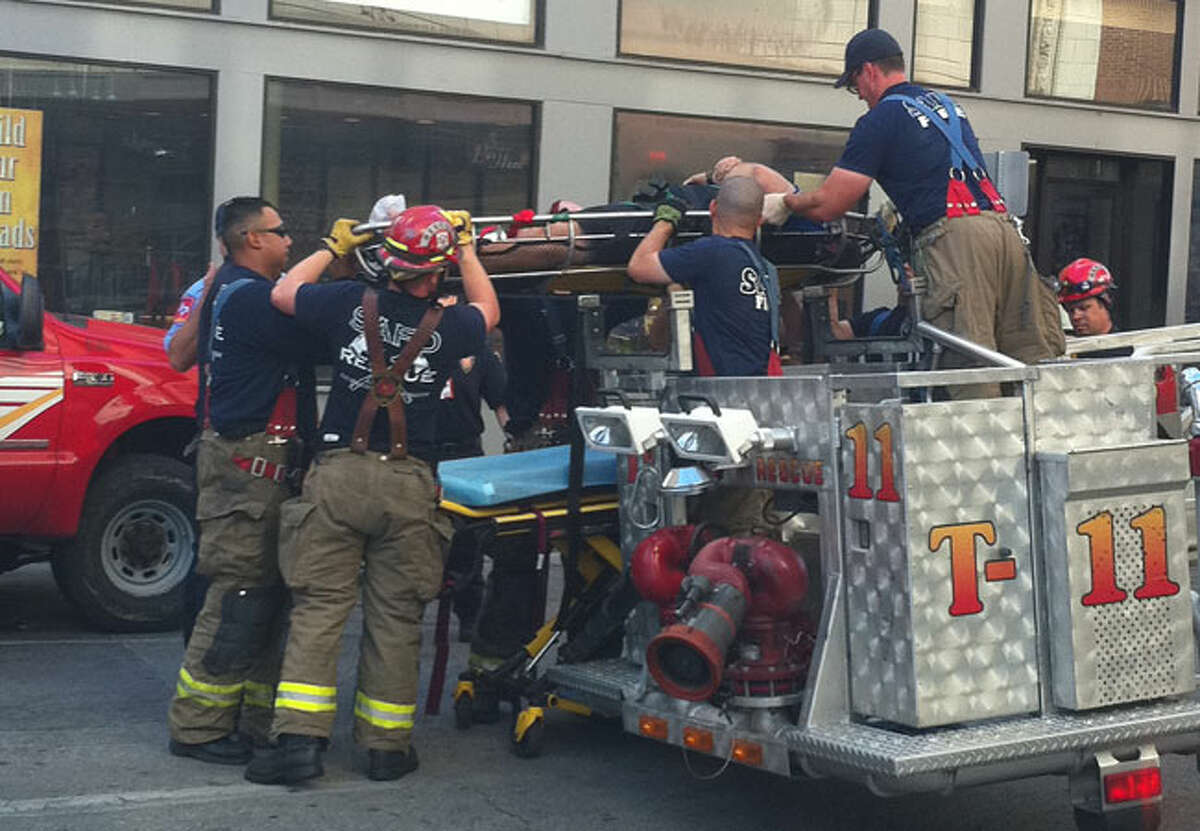 Firefighters rescue a policeman who broke his ankle while searching for a suspected copper thief on the roof of an abandoned building downtown Sunday morning.
