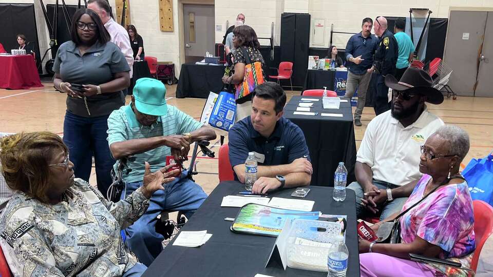 CenterPoint Energy executive Jason Wells talks with residents from northeast Houston during an open house on August 25, 2024 following prolonged outages after Hurricane Beryl.