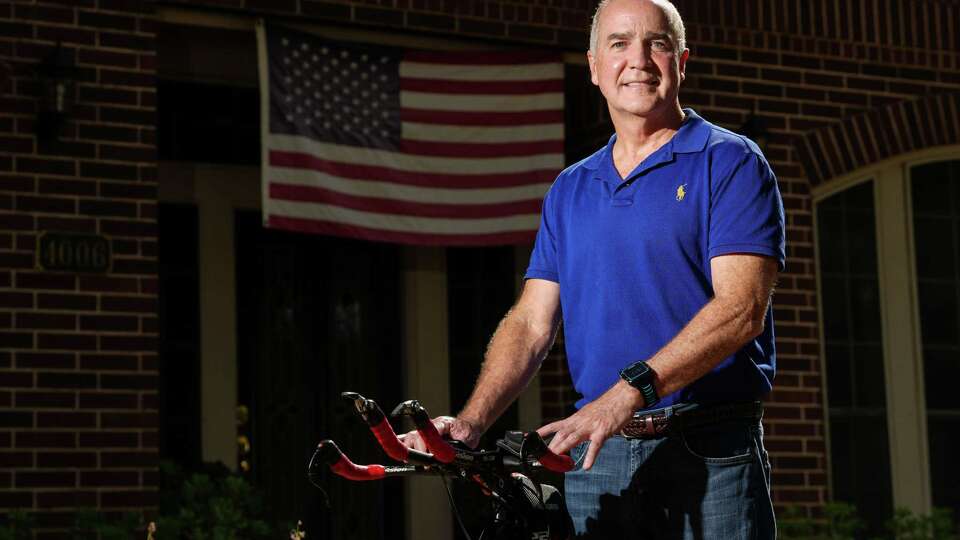 Tom O'Driscoll poses for a photo with his bike Wednesday, Aug. 28, 2024, at his home in Sugar Land. He said he has competed in several Iron Man competitions. He also said he donated his kidney and part of his liver to strangers.