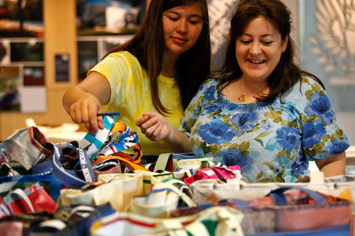 Denise Lazarine and her daughter, Christiana, look for the tote bag they made out of street banners the last time they volunteered with the Women's Pavilion project.