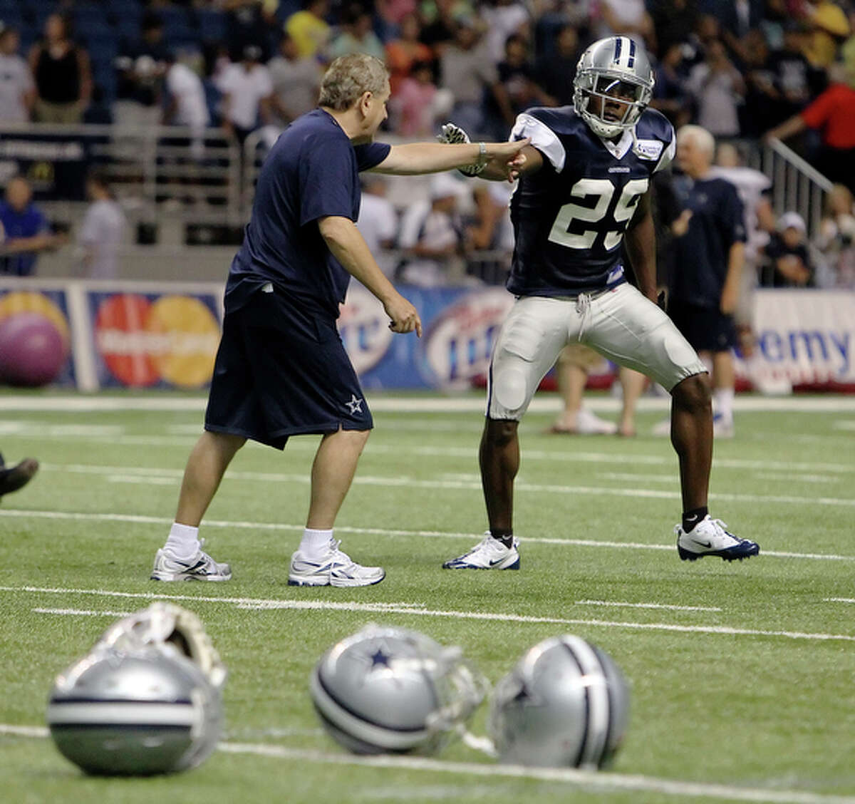 UTSA's Teddy Williams (29) gets an after-practice tutoring session with secondary coach Dave Campo at the Dallas Cowboys training camp at the Alamodome Thursday