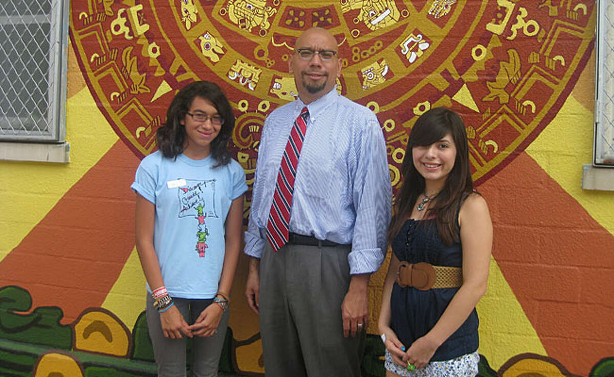 Henry Ford Academy student Sidney Fowler, Academy Principal Jeffery D. Flores and student Kennidy Monroe stand in front of the school mural that the students painted.