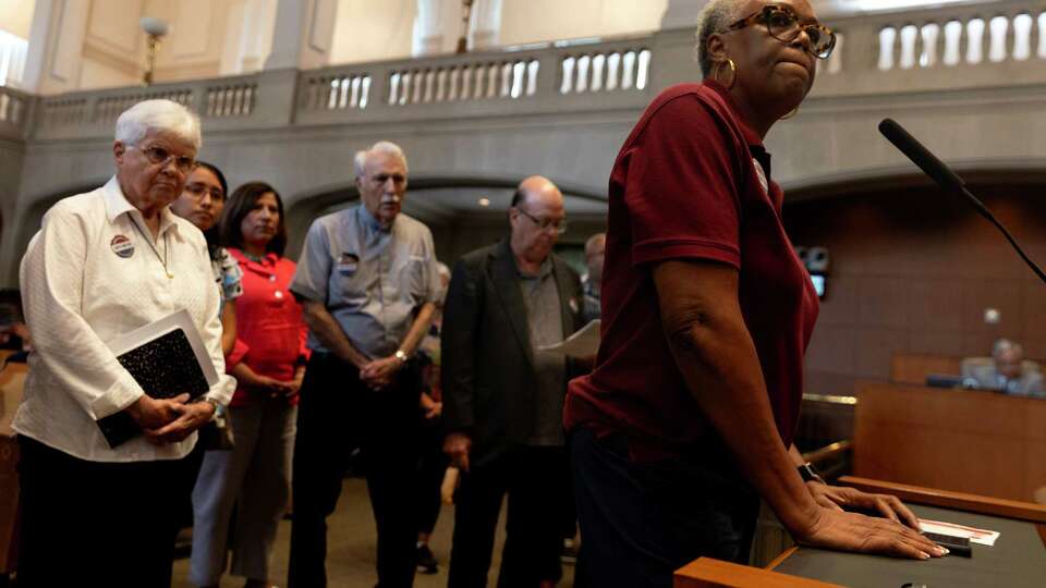 Rena Oden speaks out against the proposed stadium for the San Antonio Missions with her groupCops Metro standing behind her at a city council meeting Thursday afternoon.