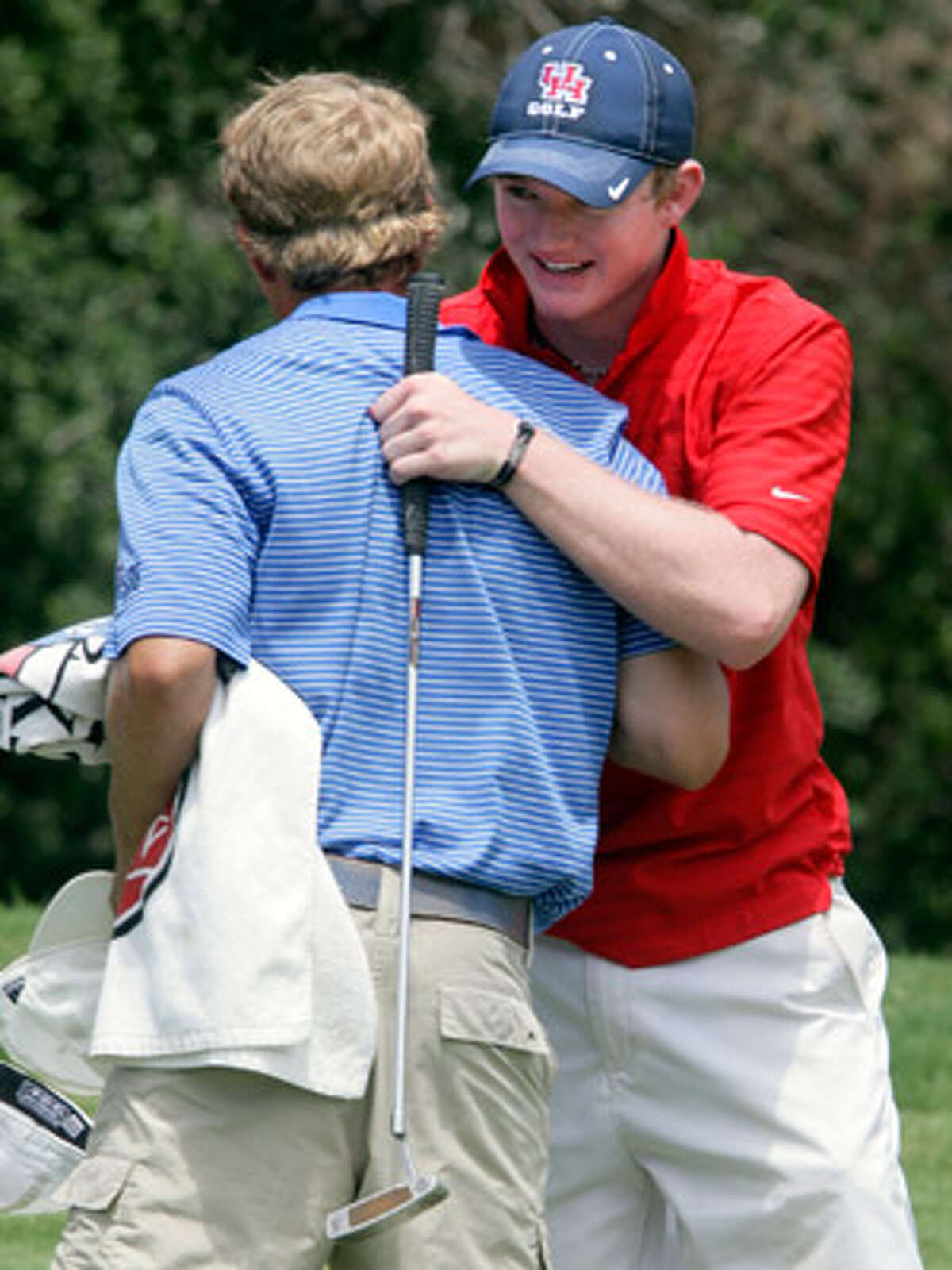 Friends Curtis Reed (right) and Andrew Carreon, two top area junior players, hug during the Valero Texas Open Junior Shootout second round on July 14. Reed will play for the University of Houston, Carreon for Notre Dame.