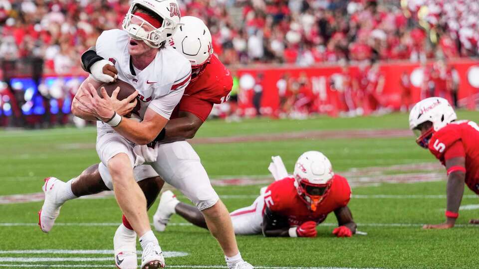 UNLV quarterback Matthew Sluka (3) is hit by Houston defensive lineman Anthony Holmes Jr. (18) as he is stopped short of the goal line during the first half of an NCAA college football game Saturday, Aug. 31, 2024, in Houston.