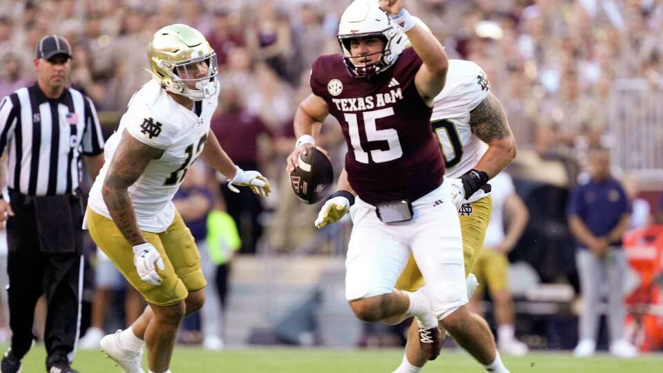 Texas A&M Aggies quarterback Conner Weigman (15) points to a wide receiver down field as he scrambles during the first quarter of a non-conference college football game at Kyle Field, Saturday, Aug. 31, 2024, in College Station.