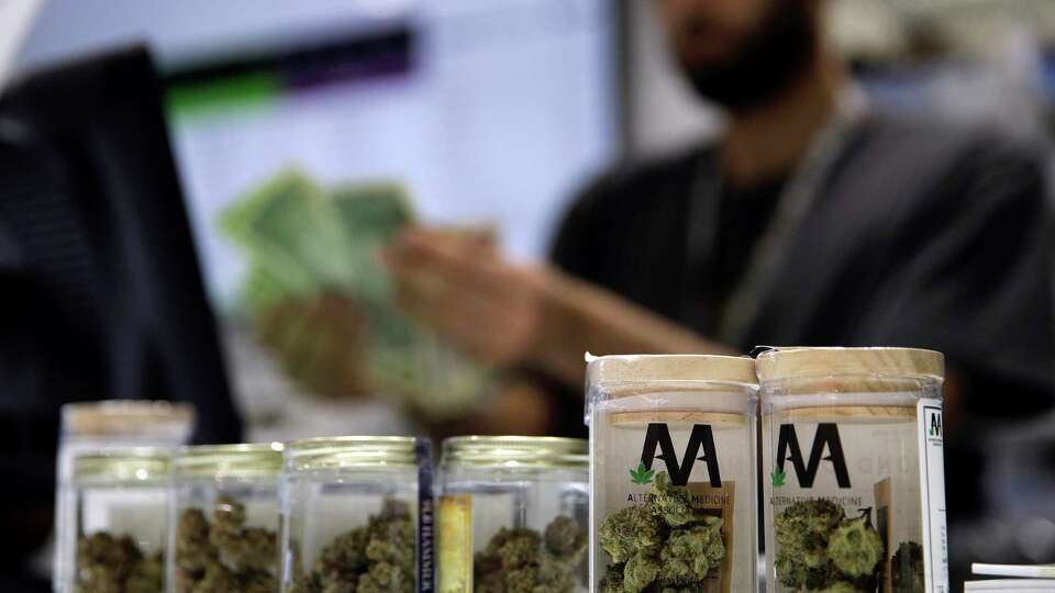 FILE - A cashier rings up a marijuana sale, July 1, 2017, at a cannabis dispensary in Las Vegas.