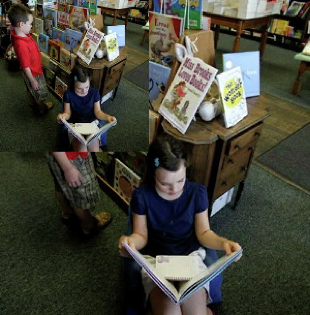 Kiley Hatch, 9, reads as her brother, John Austin Hatch, 7, browses at the Blue Willow Bookshop in Houston.