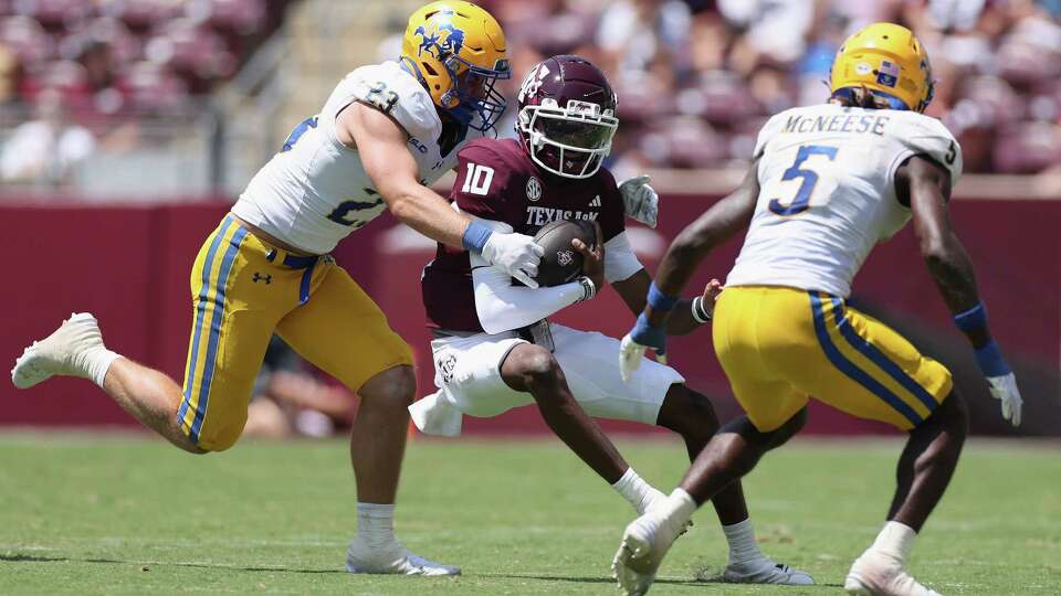 COLLEGE STATION, TEXAS - SEPTEMBER 07: Marcel Reed #10 of the Texas A&M Aggies is tackled by Peyton Lemaire #23 of the McNeese State Cowboys in the second half at Kyle Field on September 07, 2024 in College Station, Texas.