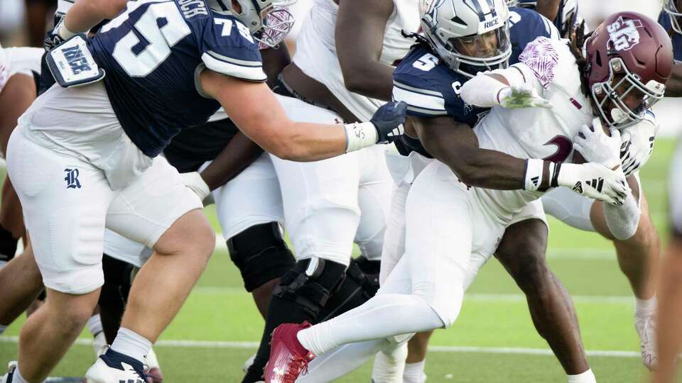 Rice linebacker Josh Pearcy (5) and defensive lineman Blake Boenisch (75) bring down Texas Southern running back Danny Green Jr. (21) during the first half of a non-conference NCAA college football game at Rice Stadium, Saturday, Sept. 7, 2024, in Houston.