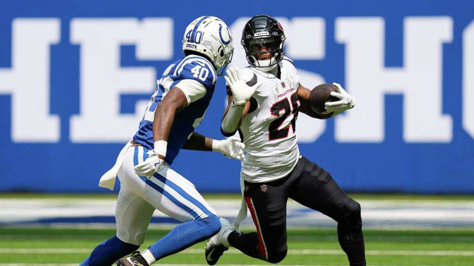 Houston Texans running back Joe Mixon (28) picks up a first down as Indianapolis Colts cornerback Jaylon Jones (40) closes in during the first half of an NFL football game at Lucas Oil Stadium, Sunday, Sept. 8, 2024, in Indianapolis.