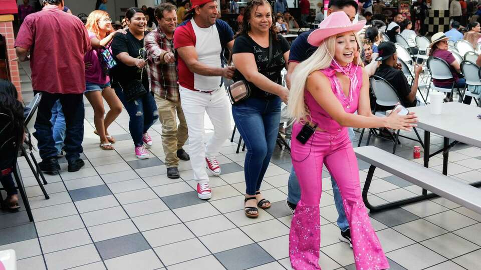 Shoppers take part in a dance line as part of an entertainment act in the food court area at PlazAmericas, formerly Sharpstown Mall, Sept. 8, 2024, in Houston. The retail complex, originally named Sharpstown Center, was the first air-conditioned mall in the U.S., when it opened on Sept. 14, 1961.