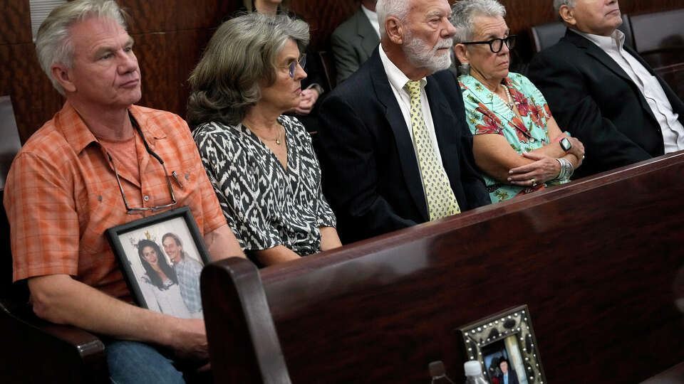 Family members of Dennis Tuttle and Rhogena Nicholas bring a photograph of the couple to the trial of retired Houston Police Department officer Gerald Goines Monday, Sept. 9, 2024 at Harris County Criminal Courthouse in Houston. Goines’ trial on two felony murder charges in the January 2019 deaths of Tuttle and Nicholas began Monday.