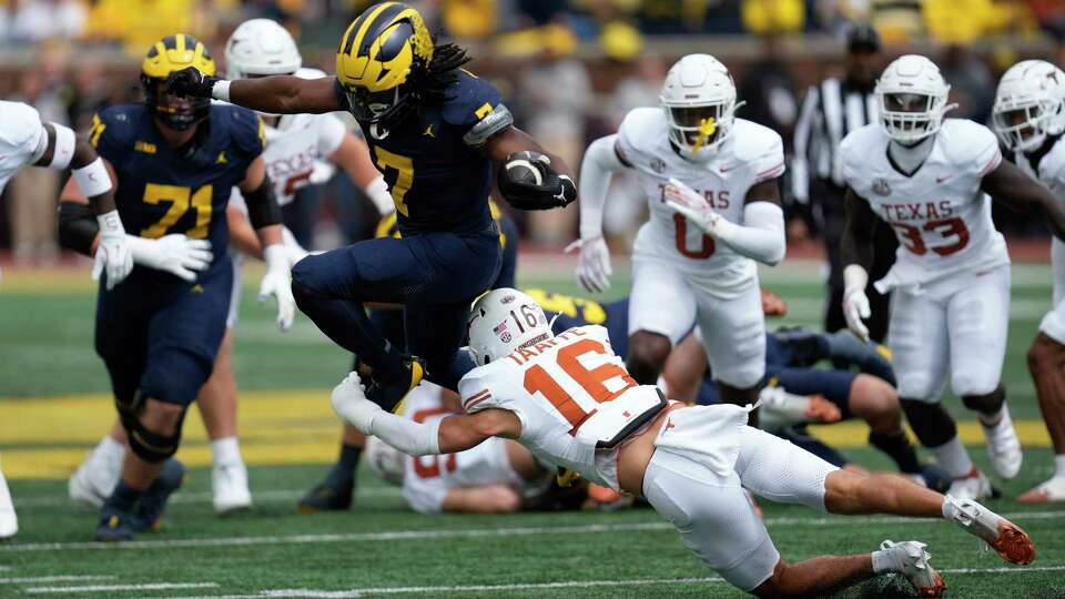 Michigan running back Donovan Edwards (7) is brought down by Texas defensive back Michael Taaffe (16) in the first half of an NCAA college football game in Ann Arbor, Mich., Saturday, Sept. 7, 2024. (AP Photo/Paul Sancya)