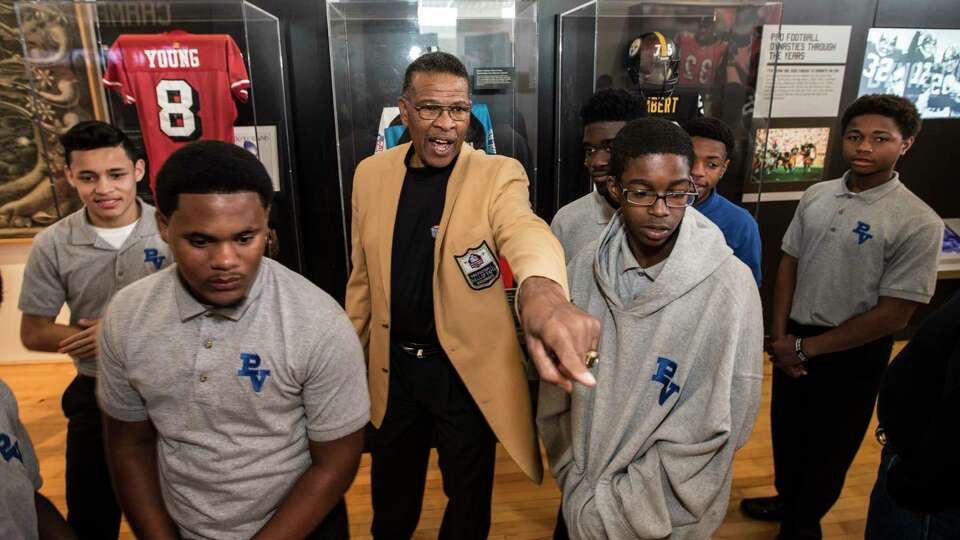 Hall of Famer Kenny Houston leads students from Pro-Vision Academy through a tour of the Pro Football Hall of Fame's Gridiron Glory, traveling exhibit on the campus of Texas Southern University on Thursday, Feb. 16, 2017, in Houston.