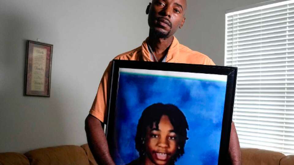 Alexis Payton poses for a portrait holding a photo of his 14-year-old son, Landon, during an interview on Tuesday, Sept. 10, 2024 in Houston. Landon Payton died suddenly after a medical emergency in the Marshall Middle School gym on Aug. 14.