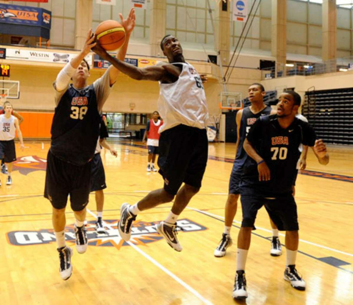 Austin Rivers (left) and Pat Young (center) compete for a rebound as Josh Hairston (right) watches during practice.