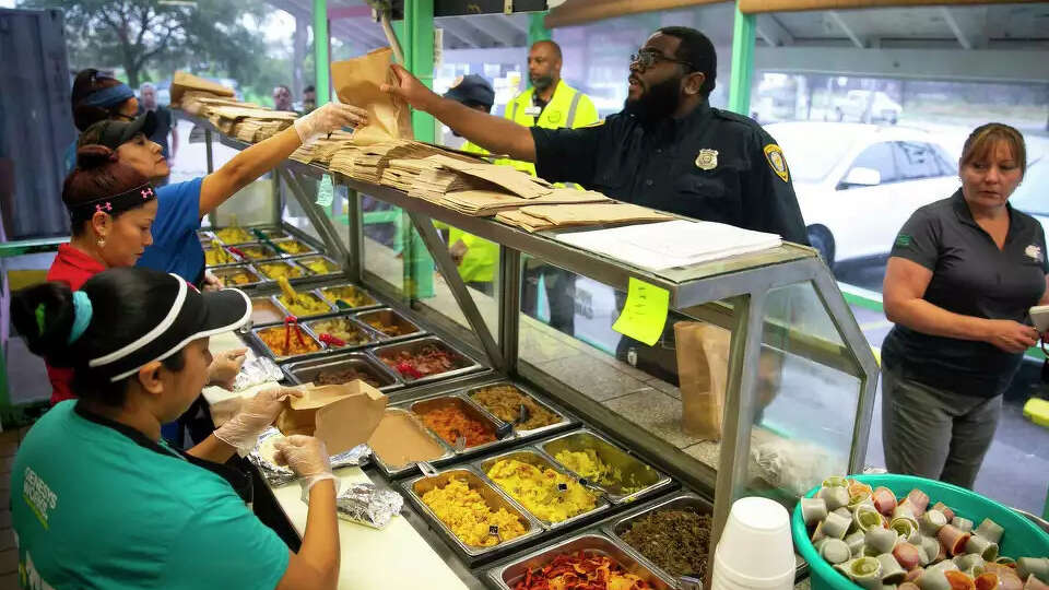 BARC officer Justin Cousan receives his taco order during breakfast at Brothers Taco House in Houston. Cousan frequently picks up breakfast for himself and a coworker.