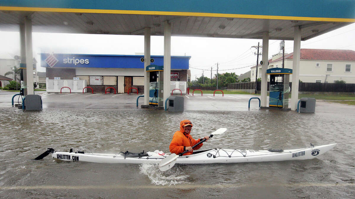 Dennis Barrett, from South Padre Island paddles his kayak along a flooded section of Padre Boulevard.