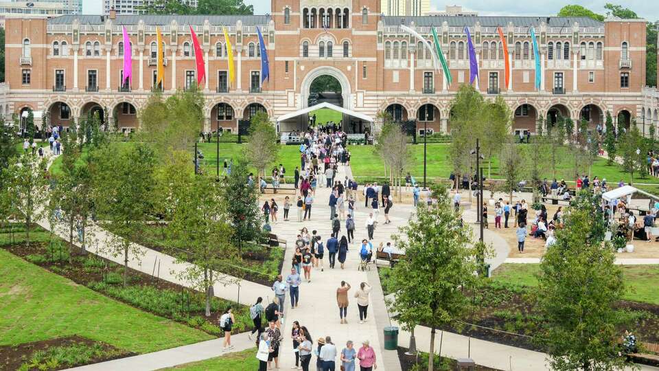 Visitors walk through the new, redesigned Academic Quad on the campus of Rice University, Thursday, Sept. 12, 2024, in Houston. The revamped, four-acre space included the refreshed pathways through the space flanked by trees, community spaces and benches and the relocation of the statue of university founder William Marsh Rice. The relocation including the addition of historical context about Rice, including his ownership of enslaved people.