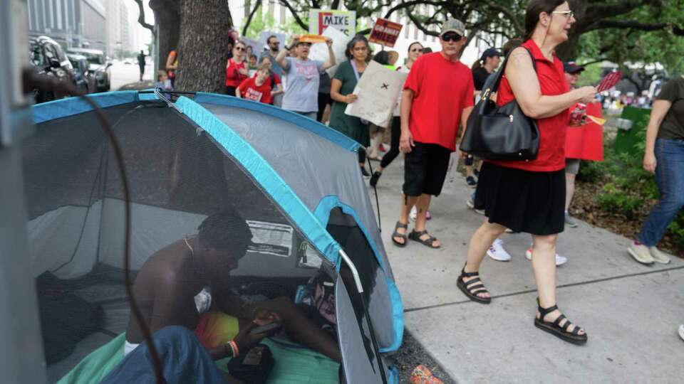 Edward Summons, 27, is seen in his tent as Hundreds of people pass by him to protest against Houston Independent School District Superintendent Mike Miles on Saturday, May 25, 2024, at Houston City Hall.