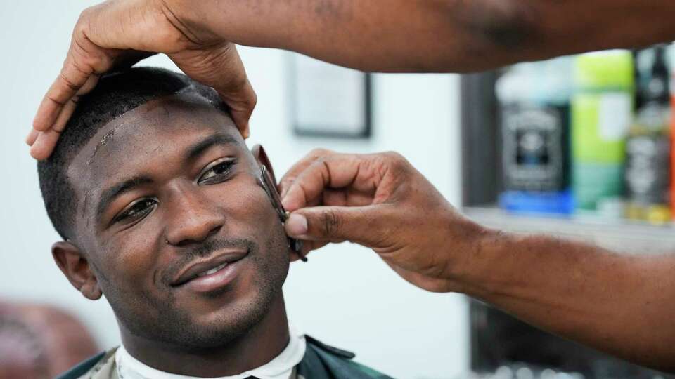 Houston Texans wide receiver Steven Sims has his hair cut by barber Shawn Miller at Nu-Era Barber Shop on Saturday, Sept. 14, 2024 in Houston. Sims has been getting his hair cut by Miller all his life.