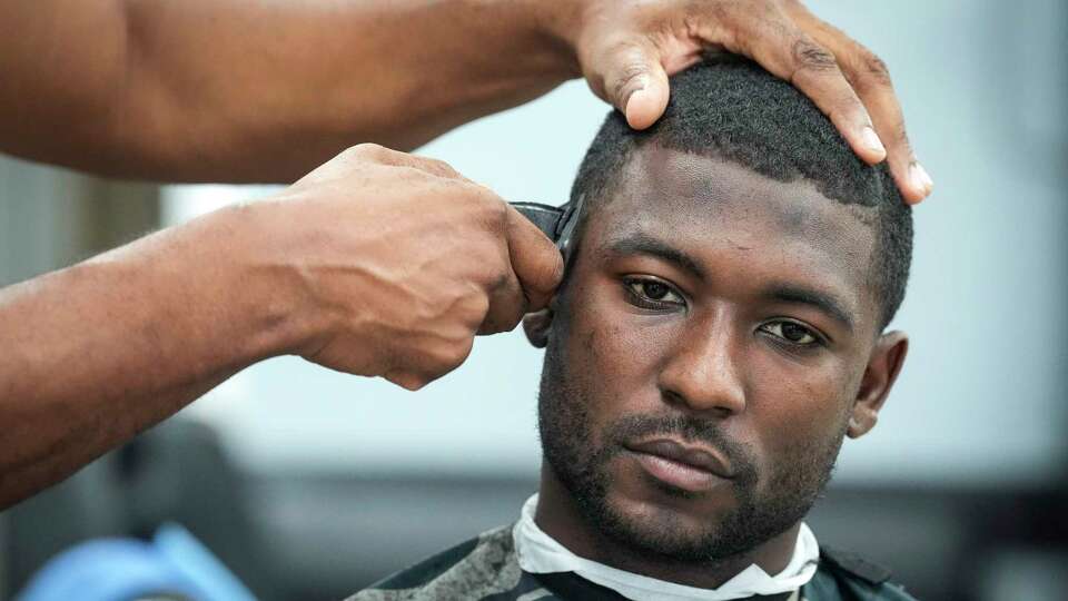 Houston Texans wide receiver Steven Sims has his hair cut by barber Shawn Miller at Nu-Era Barber Shop on Saturday, Sept. 14, 2024 in Houston. Sims has been getting his hair cut by Miller all his life.