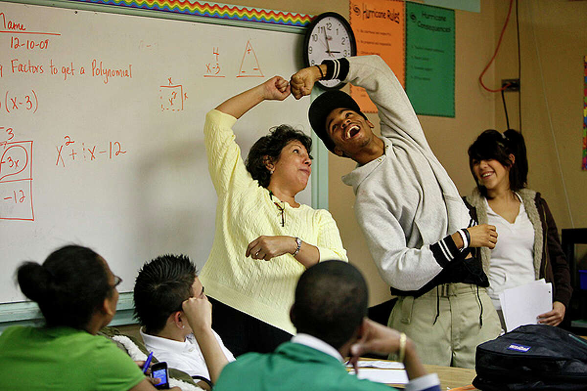 Sam Houston math teacher Lorraine Dominguez (left) does a fist bump with junior Javoi Lawson, 17, during algebra class on Dec. 10. 'She tries to encourage us to work harder but she keeps it fun and she maintains a high energy in the classroom. She tries to keep everybody up instead of being down and making everything just hard," Lawson says of Dominguez. Many of her colleagues credit her with the improved math scores at the school.