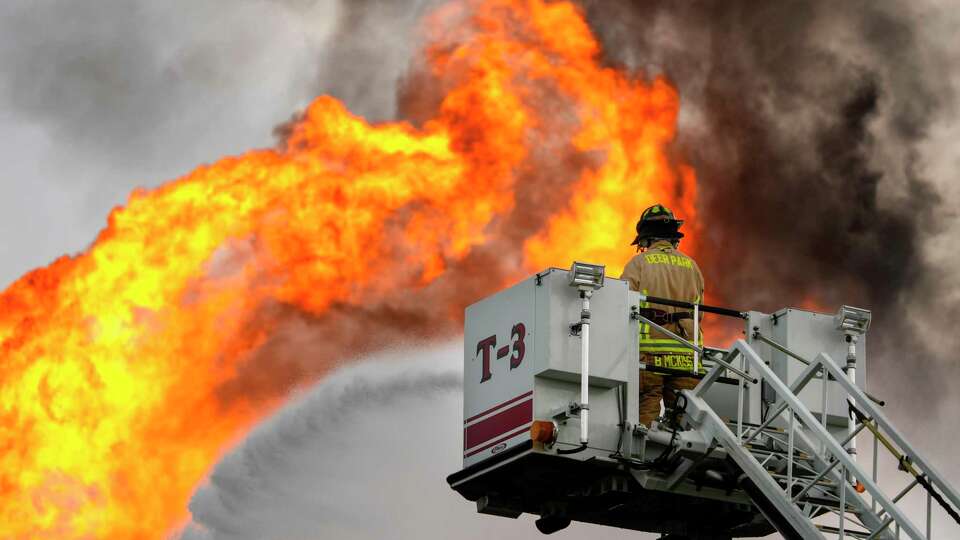 A firefighter directs a line of water around a fire on a pipeline near Spencer Highway and Summerton on Monday, Sept. 16, 2024 in La Porte. The fire caused road closures and shelter-in-place advisories Monday afternoon in the area, with evacuations to homes and businesses within a half mile from the fire site.